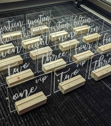 Clear acrylic table numbers with elegant white script numbering from 'one' to 'fifteen,' Rectangular