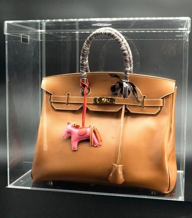 Brown luxury bag in a transparent acrylic case.