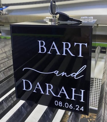 Elegant black acrylic box displaying 'Bart and Darah, 08.06.24' in white cursive font, a chic choice