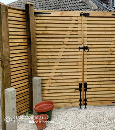 Contemporary horizontal slatted timber garden gates with black hardware installed for backyard security.