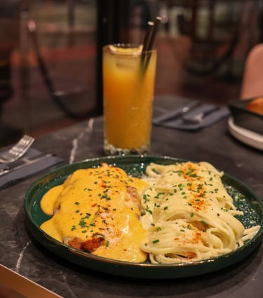 Plat de pâtes halal nappées de sauce maison servi avec cocktail frais au restaurant La Parisienne à