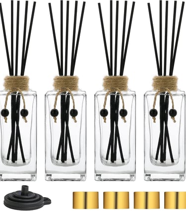 a group of four glass vases with sticks and sticks