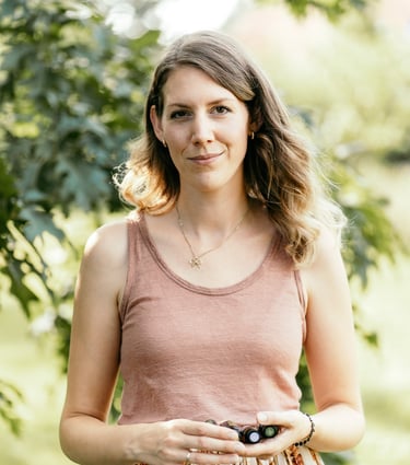 Marie, dōTERRA Wellnessbotschafterin, hält ätherisches Öl zur persönlichen Beratung