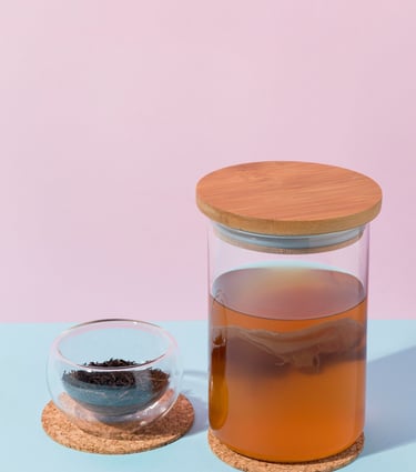 Té de kombucha casero fermentando en un frasco de vidrio con un SCOBY y té negro.