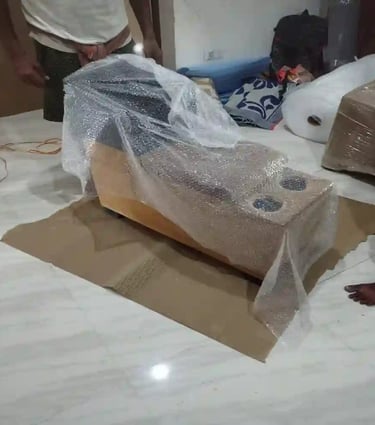 Professionally packed sofa wrapped with plastic stretch film and cardboard for household shifting.