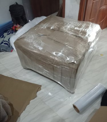 Professionally packed sofa wrapped with plastic stretch film and cardboard for household shifting.