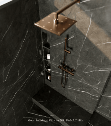 Luxurious shower detail featuring black marble shower walls with white veining and bronze fixtures