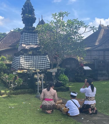 Groupe de personnes priant devant un temple balinais lors des cérémonies.