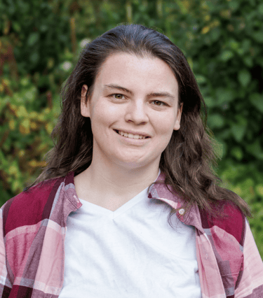 Big Gay Energy host Kaitlynn with long hair and a plaid shirt