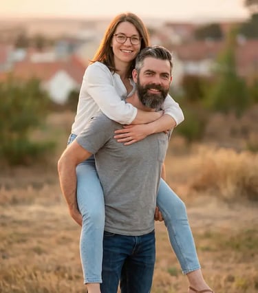Couple doing piggyback pose in Mikulov vineyards at golden hour with town backdrop