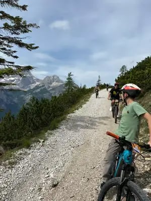 Cyclists riding gravel path on guided e-bike tour through the Italian Dolomites