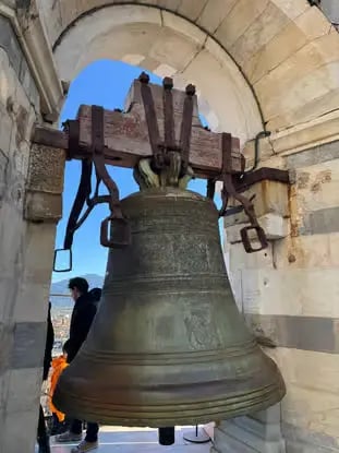 Large historic bell inside Pisa tower, seen during a Florence to Pisa day trip by train
