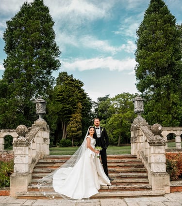 a bride and groom standing on a stone staircase