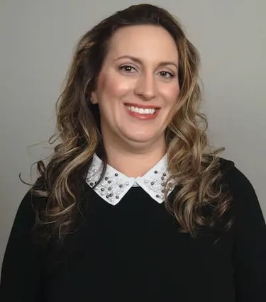 middle aged latin female smiling wearing black blouse white pearl trim