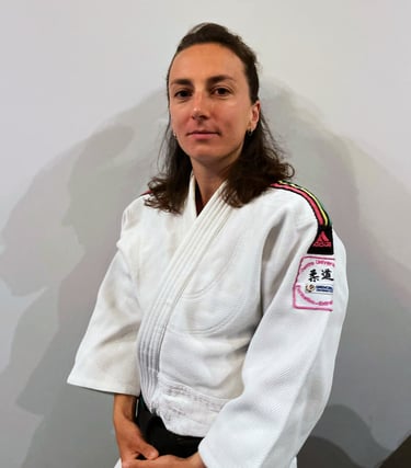 Une femme en kimono de Judo, portant une ceinture noire.