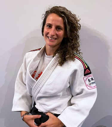 Une femme en kimono de Judo, portant une ceinture noire.
