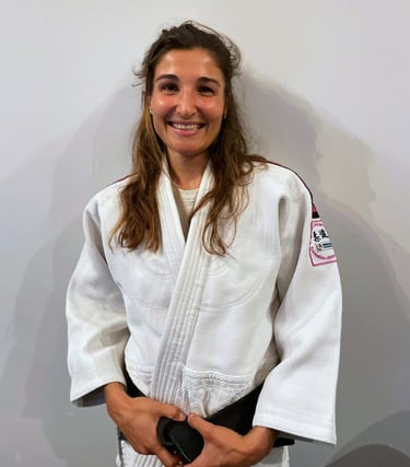 Une femme en kimono de Judo, portant une ceinture noire.