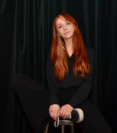 a woman sitting on a stool with a black top, marleenska