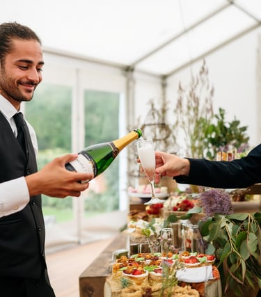 Un serveur professionnel verse du champagne à un invité lors d'une réception avec traiteu