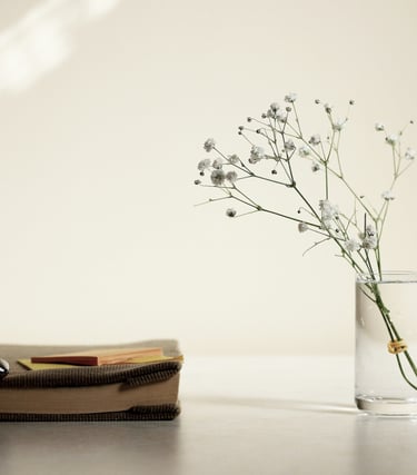Flower, vase and book on table representing energy cleansing
