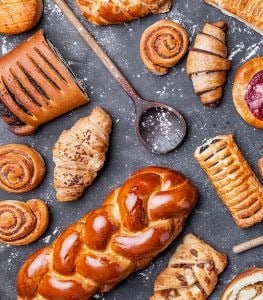 de nombreuses gourmandises sucrées et des ustensiles de cuisine sur un plan de travail