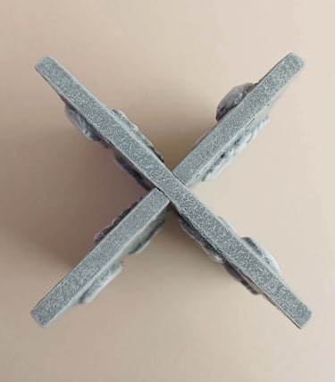 Two intersecting relief sculptures forming an X shape, and depicting three dimensional footprints.