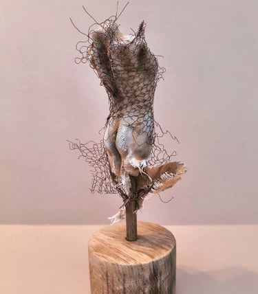 Female torso, clothed in tight fitting fabric, wrapped in torn copper wire netting