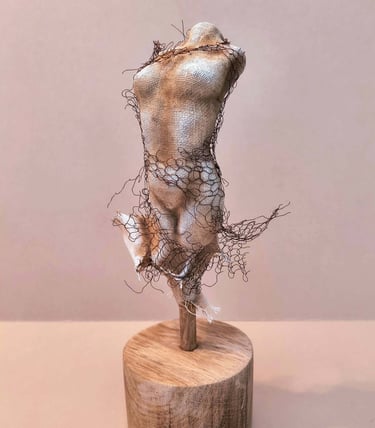 Female torso, clothed in tight fitting fabric, wrapped in torn copper wire netting