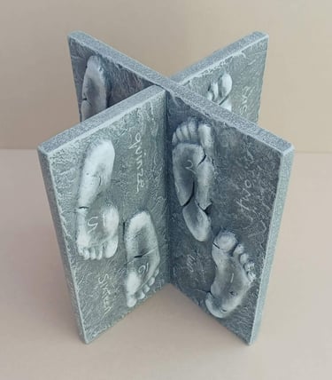 Two intersecting relief sculptures forming an X shape, and depicting three dimensional footprints.