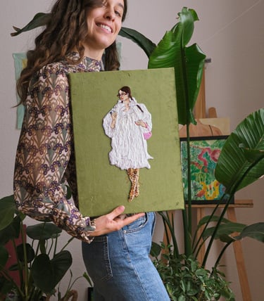 a woman holding an embroidery artwork of a woman in a dress