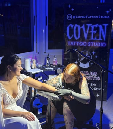 Novia recibiendo un tatuaje real en su boda, mientras el stand ofrece tattoos en vivo para invitados