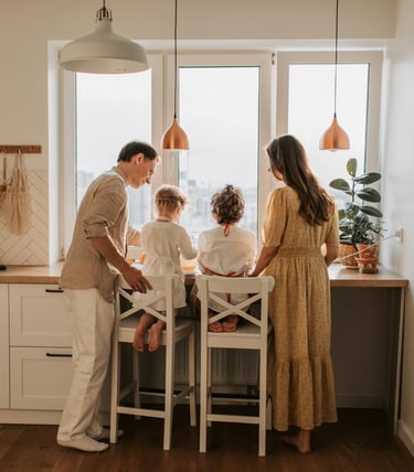 a family of four people standing around a table