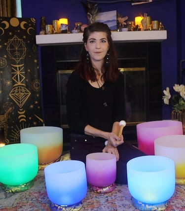 Image of a woman sitting with her crystal singing bowls