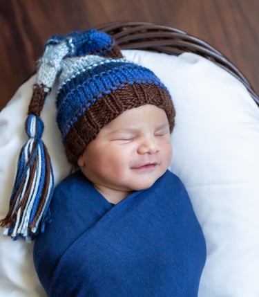 a newborn boy wearing a blue hat and a blue blanket