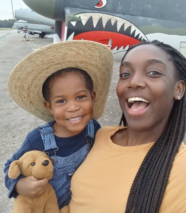 stay at home mom holding son on field trip to air field