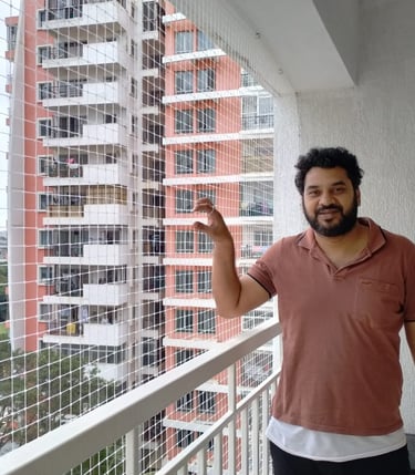 Smiling resident with newly installed pigeon nets in Indiranagar Bangalore