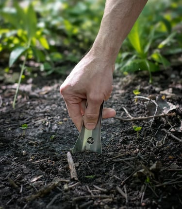 Hand pushing boglerco trowel into ground