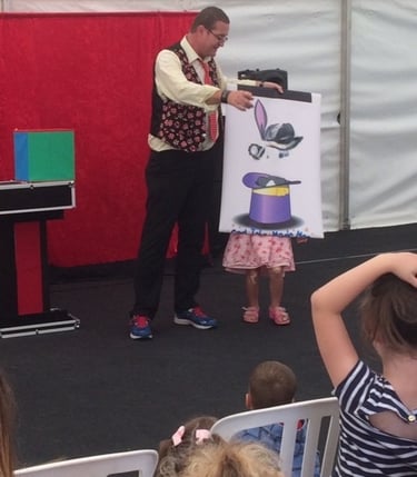 Cardiff Magician Carl The Magician performing a magic trick with a "rabbit in a hat" for an audience