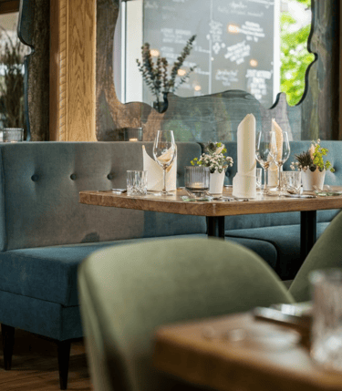 Modern restaurant interior with wooden tables and upholstered seating – BFS HORECA and public spaces furniture project.