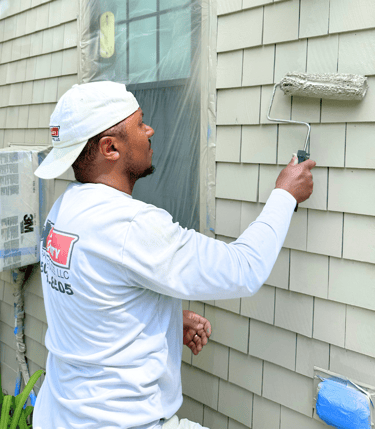 a man painting a house; exterior painting