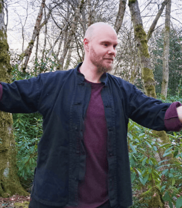 male tai chi teacher practicing outdoors in nature