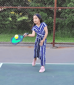 a girl in a dress playing tennis