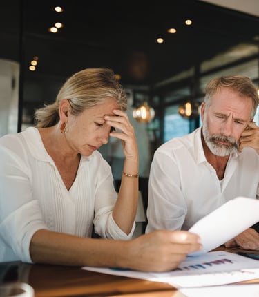 a man and woman sitting at a table with papers