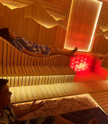 woman and man are sitting in a wooden hot stone sauna