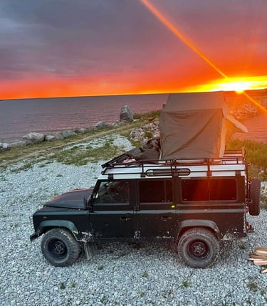 Roof tent on Land Rover with sunset 