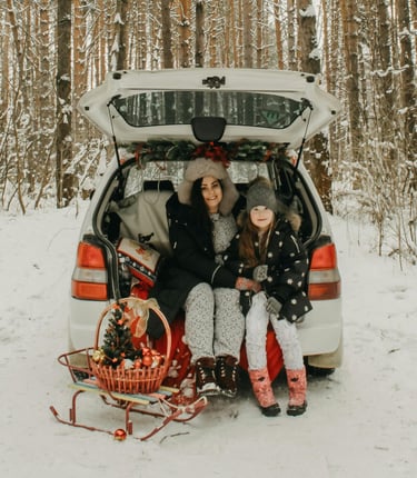 mother and daughter sitting in the trunk of a car