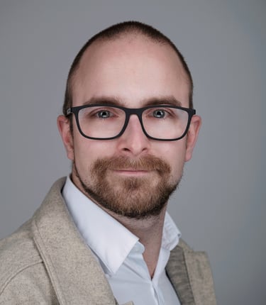portrait of a man with a beard and glasses on his face