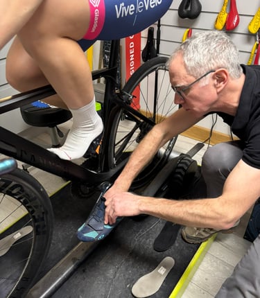 Close-up of a rider having their shoes adjusted by a bike fitter