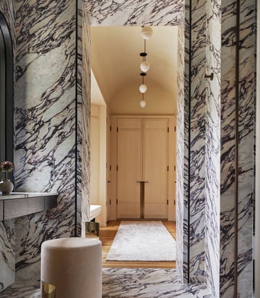 Kelly Wearstler design- bathroom with a marbled floor and a stool.