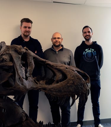 Photo of the team with a full sized replica of a T-Rex skull